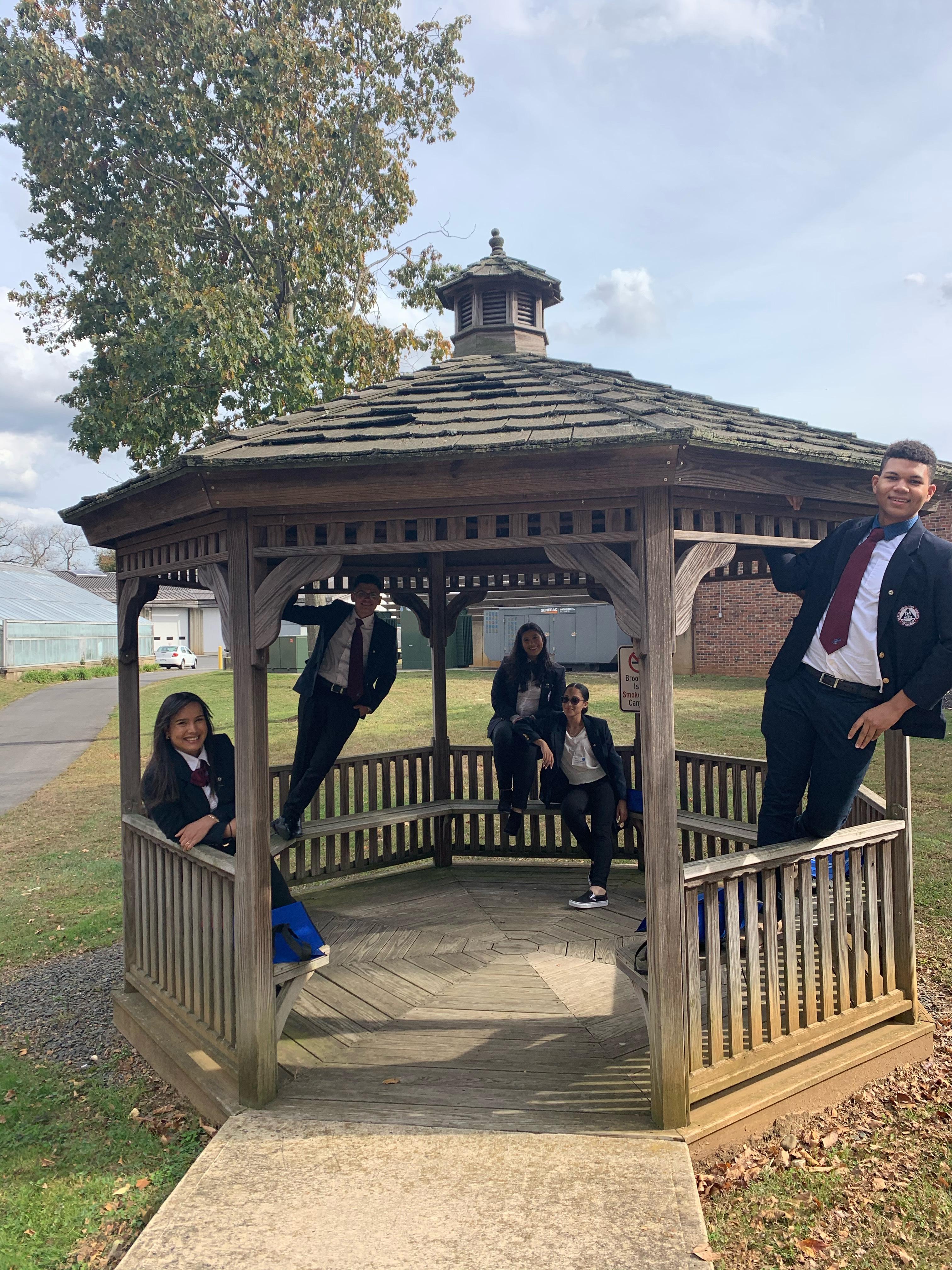 HOSA officers standing and sitting in a gazebo
